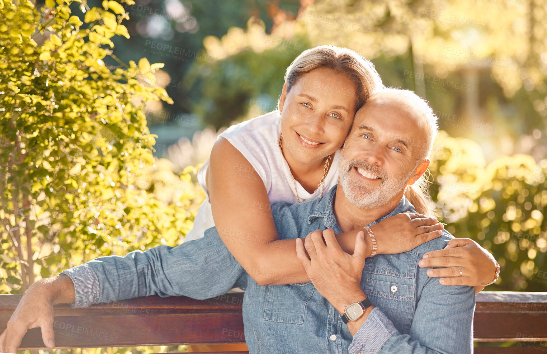 Buy stock photo Nature, bench and portrait of a senior couple relaxing in an outdoor green garden together. Happy, smile and elderly man and woman in retirement embracing, bonding and sitting in a park in Australia.