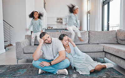 Buy stock photo Tired, parents and children jump on sofa with frustrated mom and dad sitting on floor in living room. Family, exhausted couple and playful kids with energy jumping on couch at home during quarantine