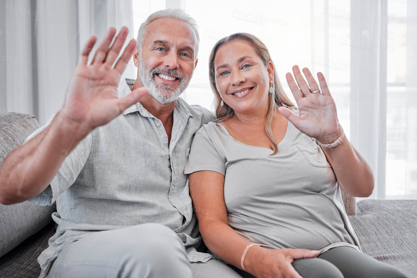 Buy stock photo Elderly couple, relax and smile in hello for introduction, waving hands or video call on living room sofa at home. Portrait of happy senior man and woman smiling in happiness for communication