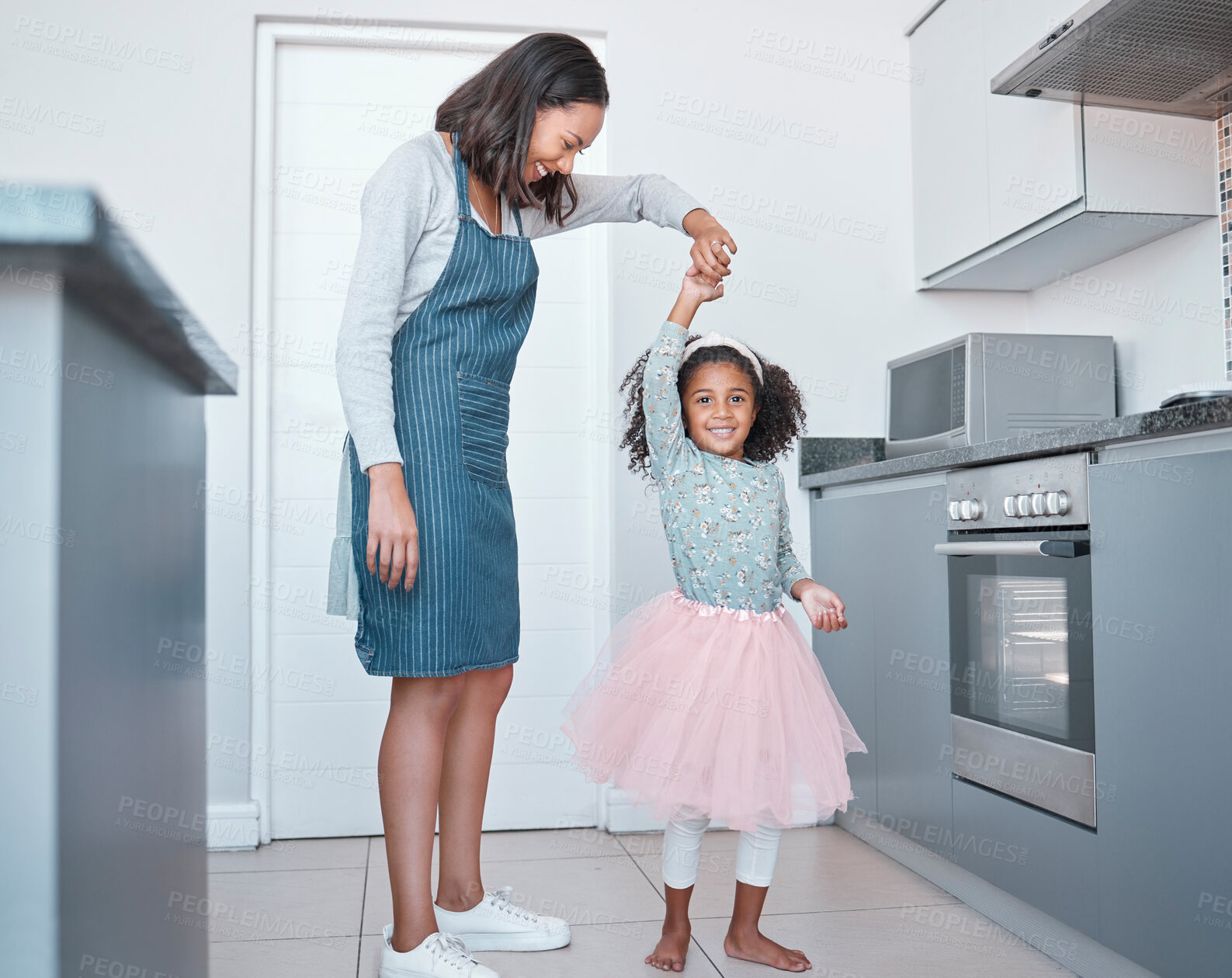 Buy stock photo Mother, child and dancing in home kitchen for love, energy and fun together as a family with happiness, care and support. Black woman and girl or daughter with princess tutu to dance while cooking