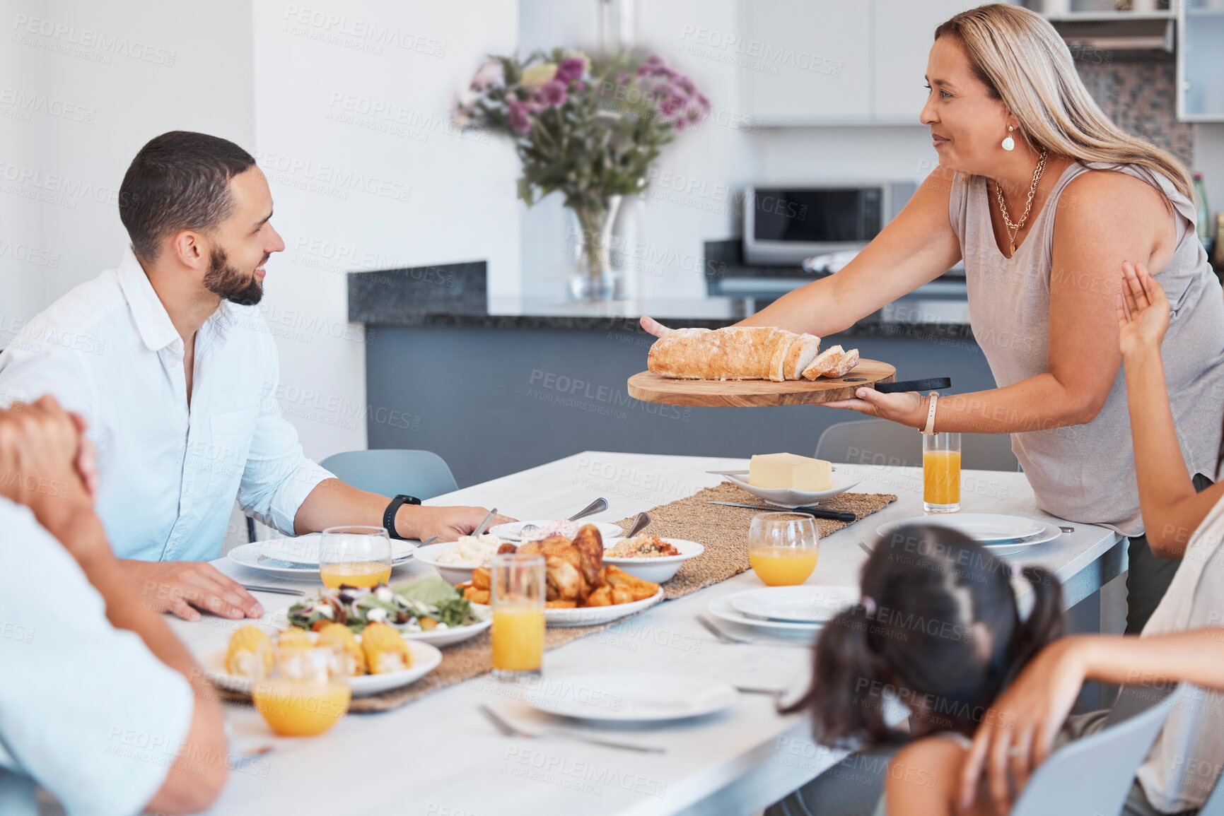Buy stock photo Lunch celebration, party and big family eating at a dining room table with love, smile and communication. Food, relax and senior woman serving dinner or breakfast to celebrate a holiday together