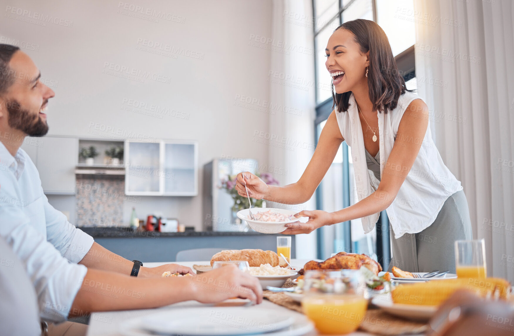 Buy stock photo Happy, smile and couple eating dinner together at the dining room table in their modern house. Happiness, love and woman dishing food for her husband while enjoying a meal on a date at their home.