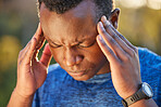 Headache, pain and stress of a man hiking in nature on a trail for health, wellness and fitness. Adventure, medical emergency and African guy holding his injured head while trekking in the woods.