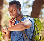 Hiking, backpack and pulse of man athlete in the woods using a watch to check time and heartbeat. Hiker, adventure and smart watch with athletic, fit male checking neck heart rate while working out