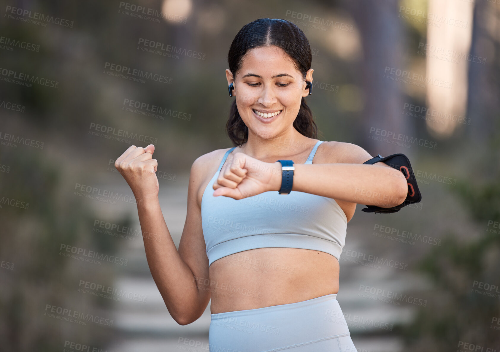 Buy stock photo Fitness, exercise and woman celebrate goal with watch to check pulse, performance and time while in forest or nature for cardio workout and running. Female outdoor for training with smartwatch