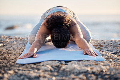 Buy stock photo Yoga, meditate and fitness with a woman on a rock at the beach for mental health, wellness or exercise. Training, workout and meditation with a female athlete stretching outdoor in nature for health