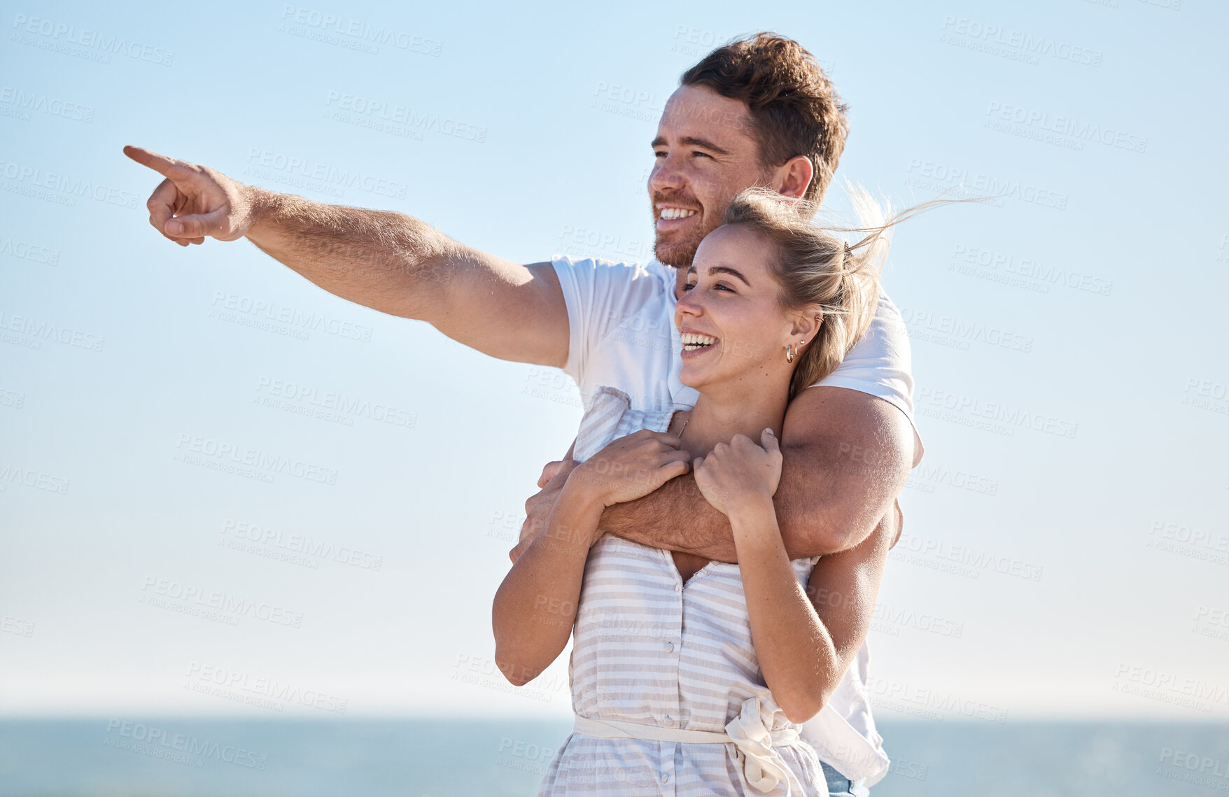 Buy stock photo Travel, couple and hug at beach with pointing for sightseeing, discovery and holiday in Australia. Ocean, explore and happy people enjoy summer vacation sunshine and romance with blue sky mockup.