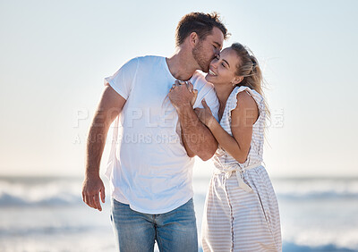 Buy stock photo Happy, love and couple at the beach while on a vacation for romance, honeymoon or relaxation. Happiness, kiss and young man and woman walking by the ocean while on romantic holiday adventure together