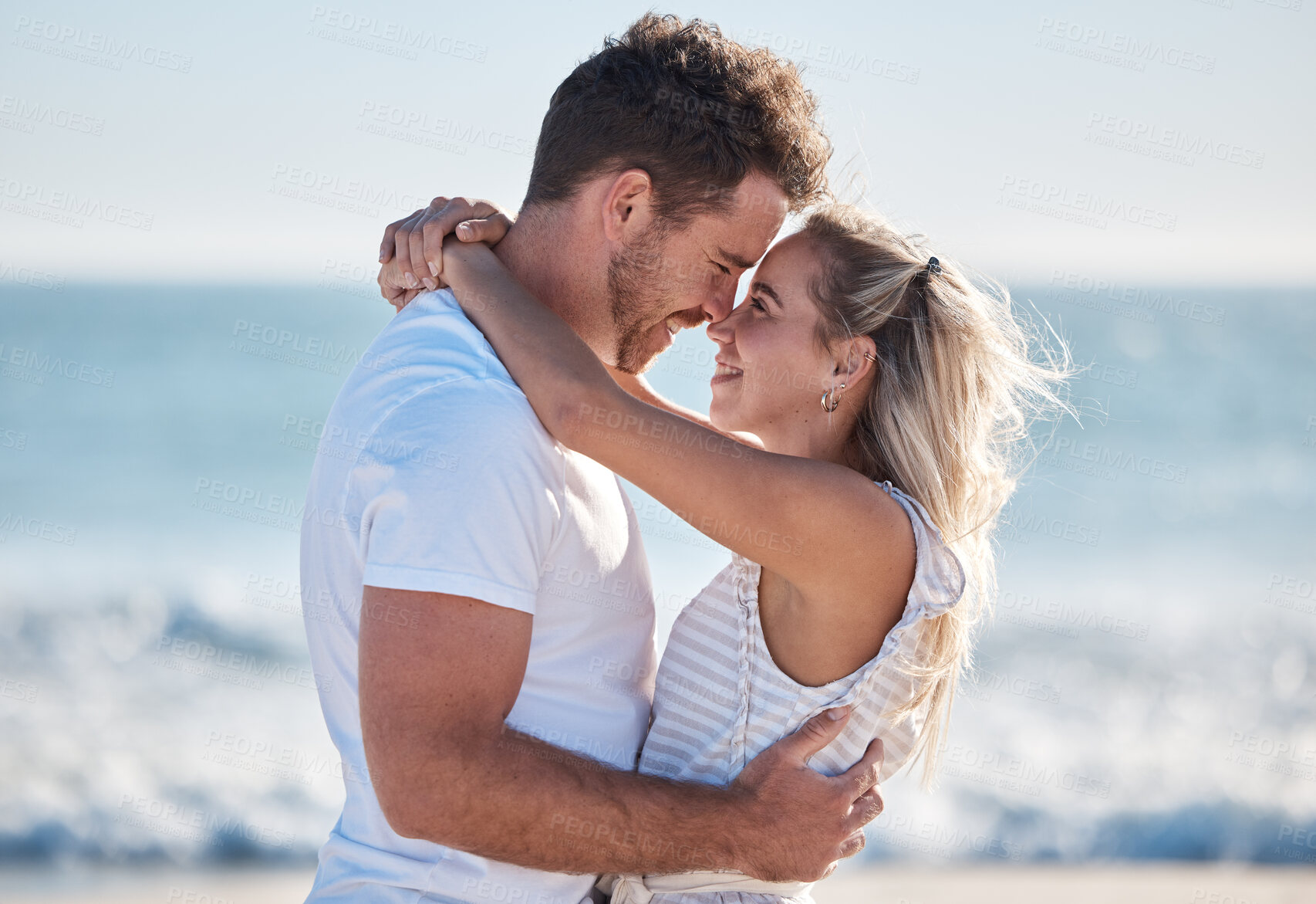 Buy stock photo Couple, love and hug at the beach together, nose touch and bonding with travel and date by the ocean for summer holiday. Happy, man and woman with quality time, sea waves and romantic out in nature.