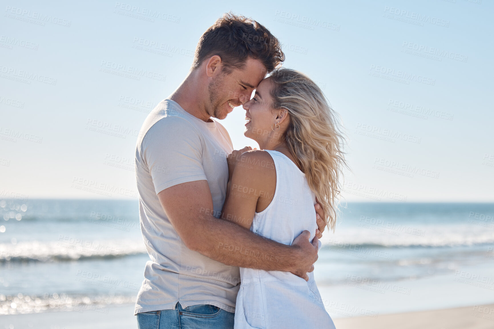 Buy stock photo Couple, love and hug in relationship at the beach for summer vacation or romantic bonding in the outdoors. Happy man and woman hugging with smile together in loving embrace for romance by the ocean