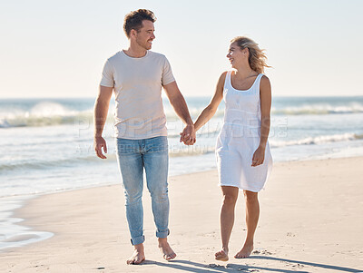 Buy stock photo Couple, holding hands and walking on the beach for love, care or relationship bonding together in the outdoors. Happy man and woman relaxing on a lovely walk on the sandy ocean coast for romance