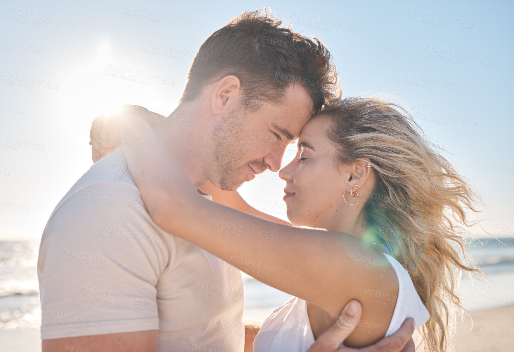 Buy stock photo Love, travel and couple hugging at the beach while on a seaside date or honeymoon vacation. Affection, romance and young man and woman embracing while on a romantic holiday adventure by the ocean.