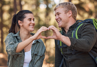 Buy stock photo Love, couple and heart hands while hiking in nature for affection or support. Emoji, hand gesture and romance or intimacy shape with happy man and woman on adventure or trekking outdoors in forest.