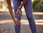 Knee pain, injury and accident of a woman training for a running marathon, race or competition in nature. Sprain bone, injured leg and swollen muscle of athlete doing cardio exercise on outdoor trail