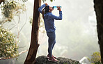 Hiking, woman and drinking water in nature, forest and mountain for healthy lifestyle, wellness and outdoor adventure. Young girl, water bottle and trekking, mountains and freedom, relax and travel 