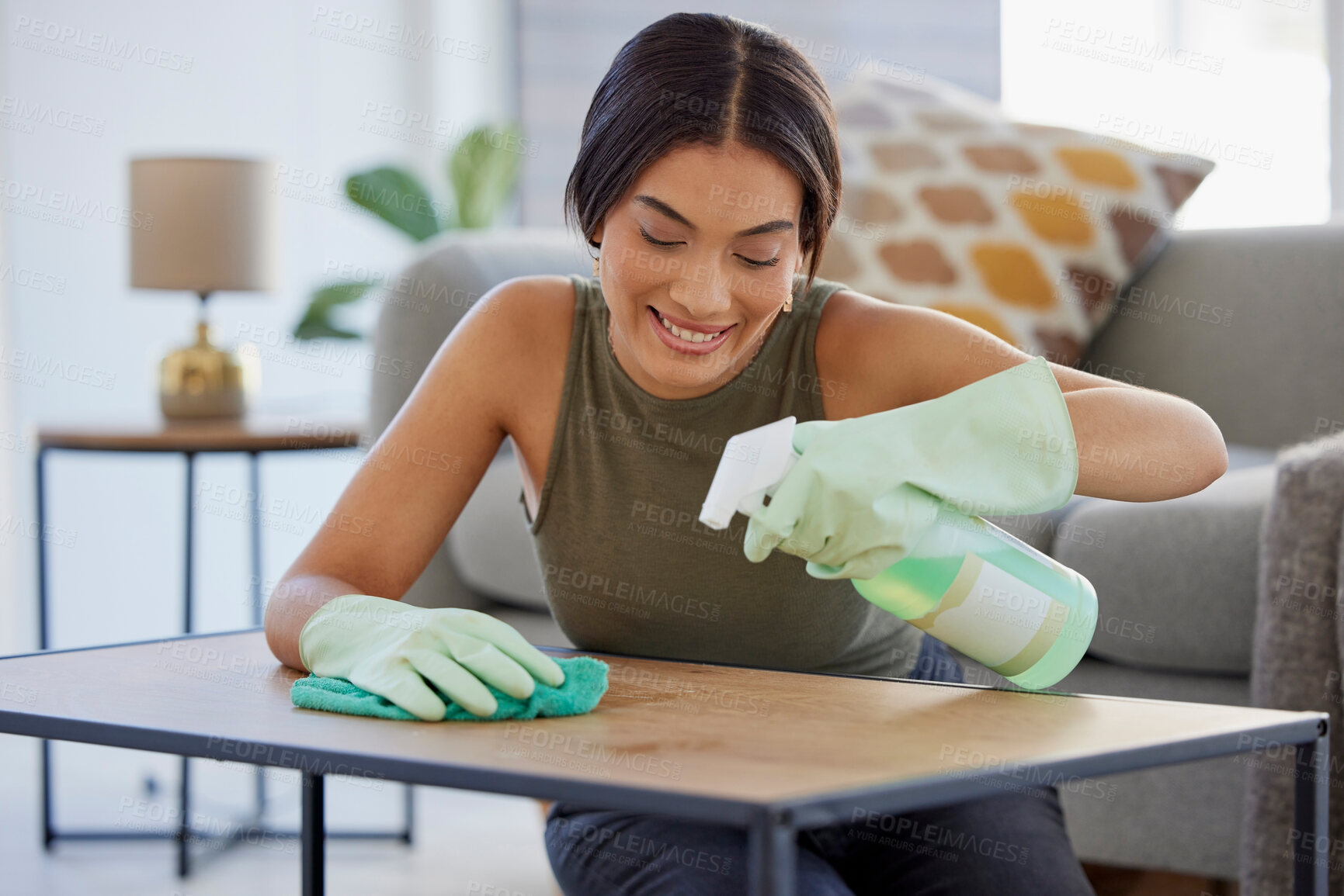 Buy stock photo Woman, detergent and smile for cleaning table, hygiene or sanitary wiping in the living room at home. Female spraying anti bacterial liquid cleaner on wooden desk for health safety and hygienic house