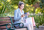 Woman phone, park and shopping bags with a person on social media app and mobile texting. Young female online on 5g internet and mobile phone happy about shop sale purchase and technology outdoor