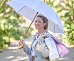 Sun, umbrella and woman with bags from shopping with smile and happy walking in park. Summer, nature and girl with shopping bags from luxury designer boutique and protection from uv rays in sunshine.