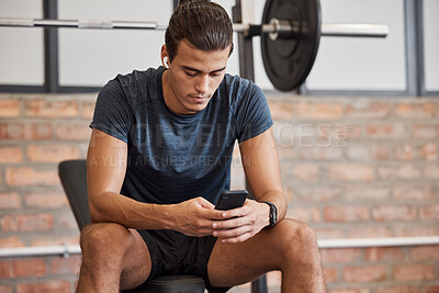 Buy stock photo Fitness, relax and phone with man in gym for training, workout or exercise. Social media, internet and music with bodybuilder athlete and mobile for health, wellness or performance in sport club