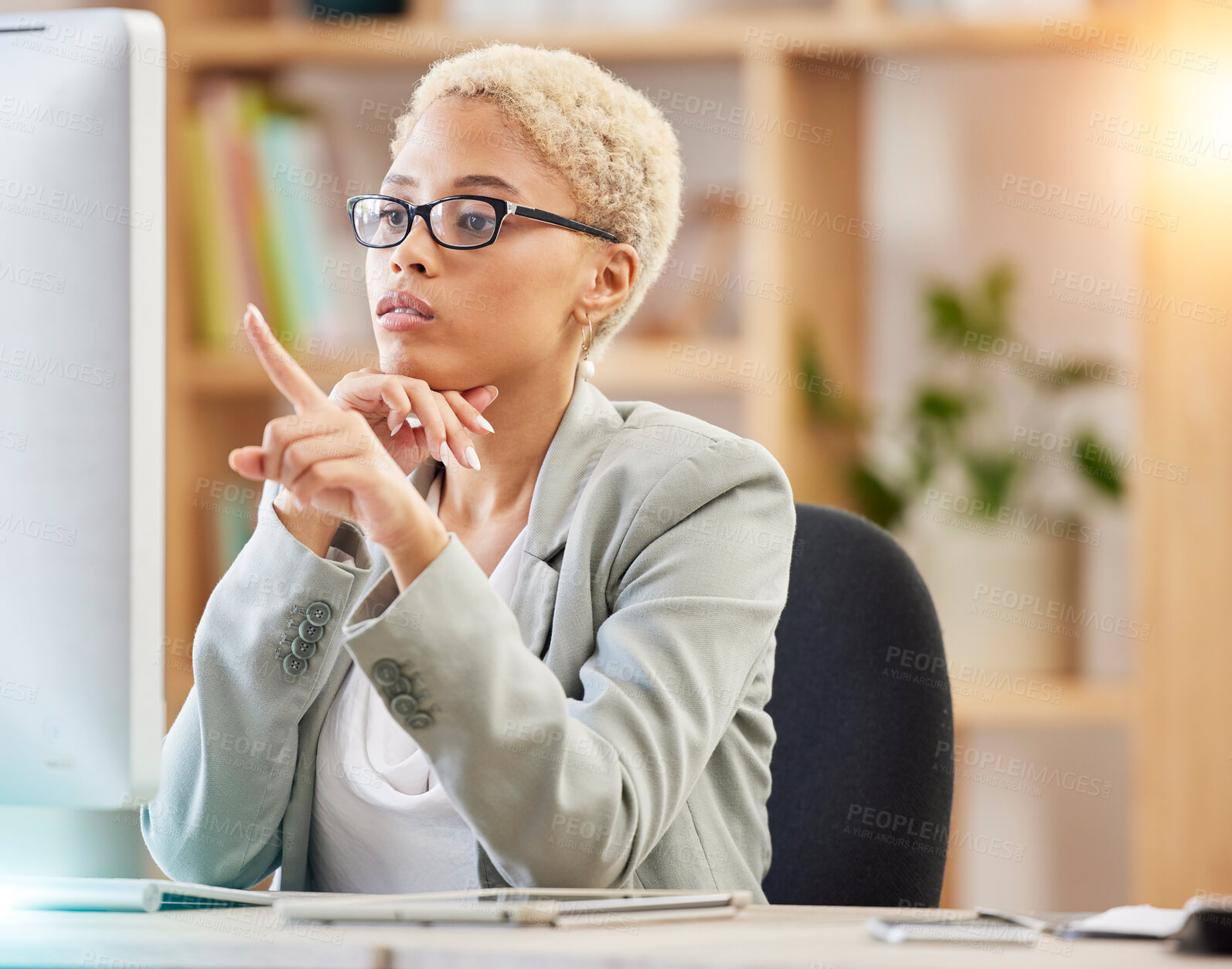 Buy stock photo Black woman, computer and office desk while pointing at screen for accounting, finance and analysis on web. Woman, pc and focus research, technology and reading documents, report or analytics at job