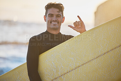 Man, surfer and beach in portrait with surfboard, smile and hang loose sign for outdoor sunshine. Happy, ocean and guy with hang ten hand, summer sunset and surfing by sea for water sport exercise