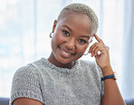 Happy, smile and portrait of a black woman relaxing in a living room at a house on a holiday, break or weekend. Happiness, calm and African lady sitting alone in her lounge in her home or apartment.