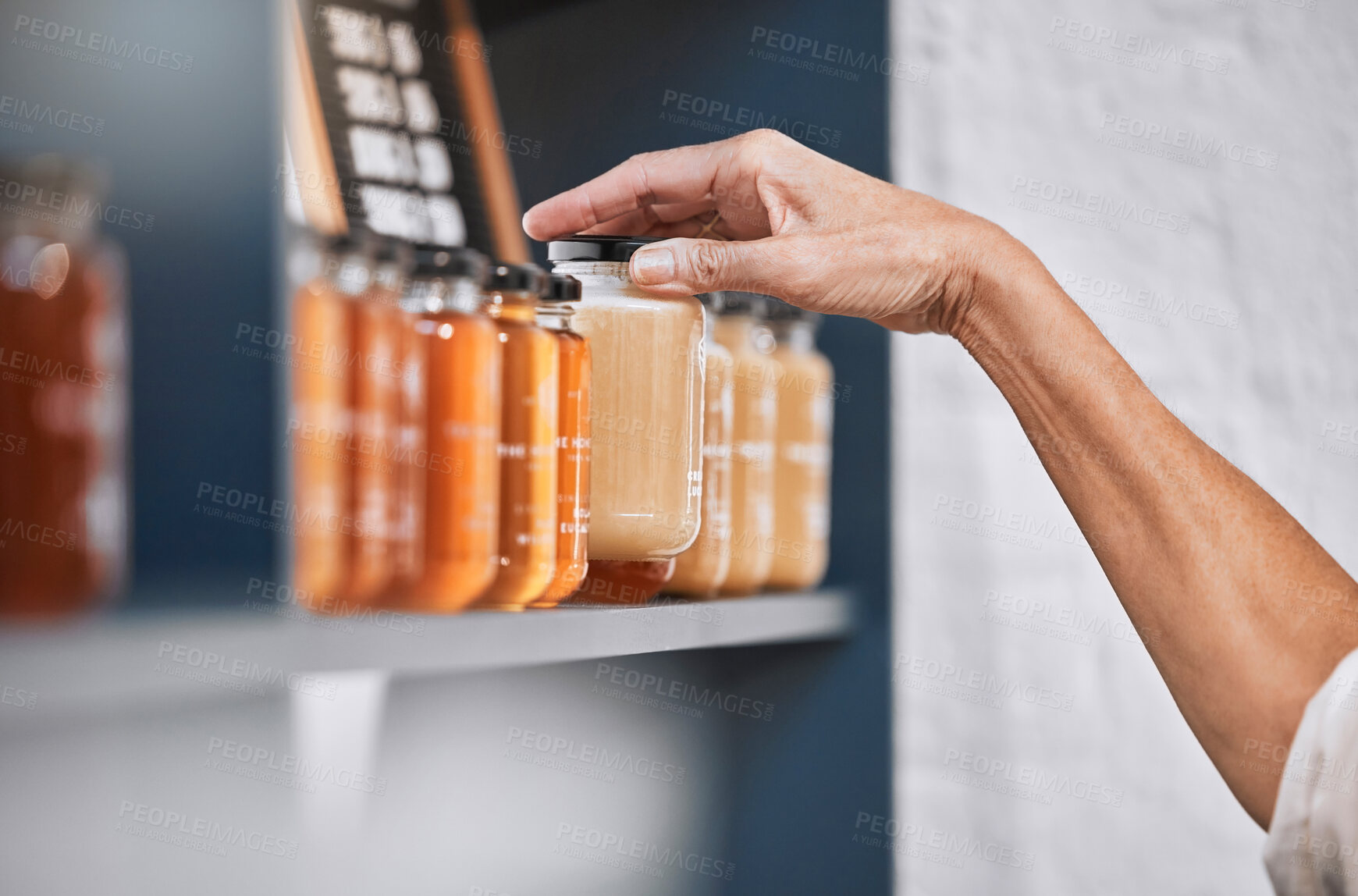 Buy stock photo Honey, product and retail with hands of woman for natural, supermarket and grocery shopping shelf. Food, health and sustainability with organic store employee for small business, sale and choice