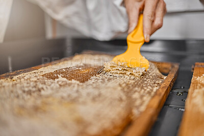 Buy stock photo Beekeeper, hand and honey process, production and manufacturing in a factory, workshop and workplace. Frame, scraping and honeycomb with equipment for beeswax on a sustainability farm or warehouse