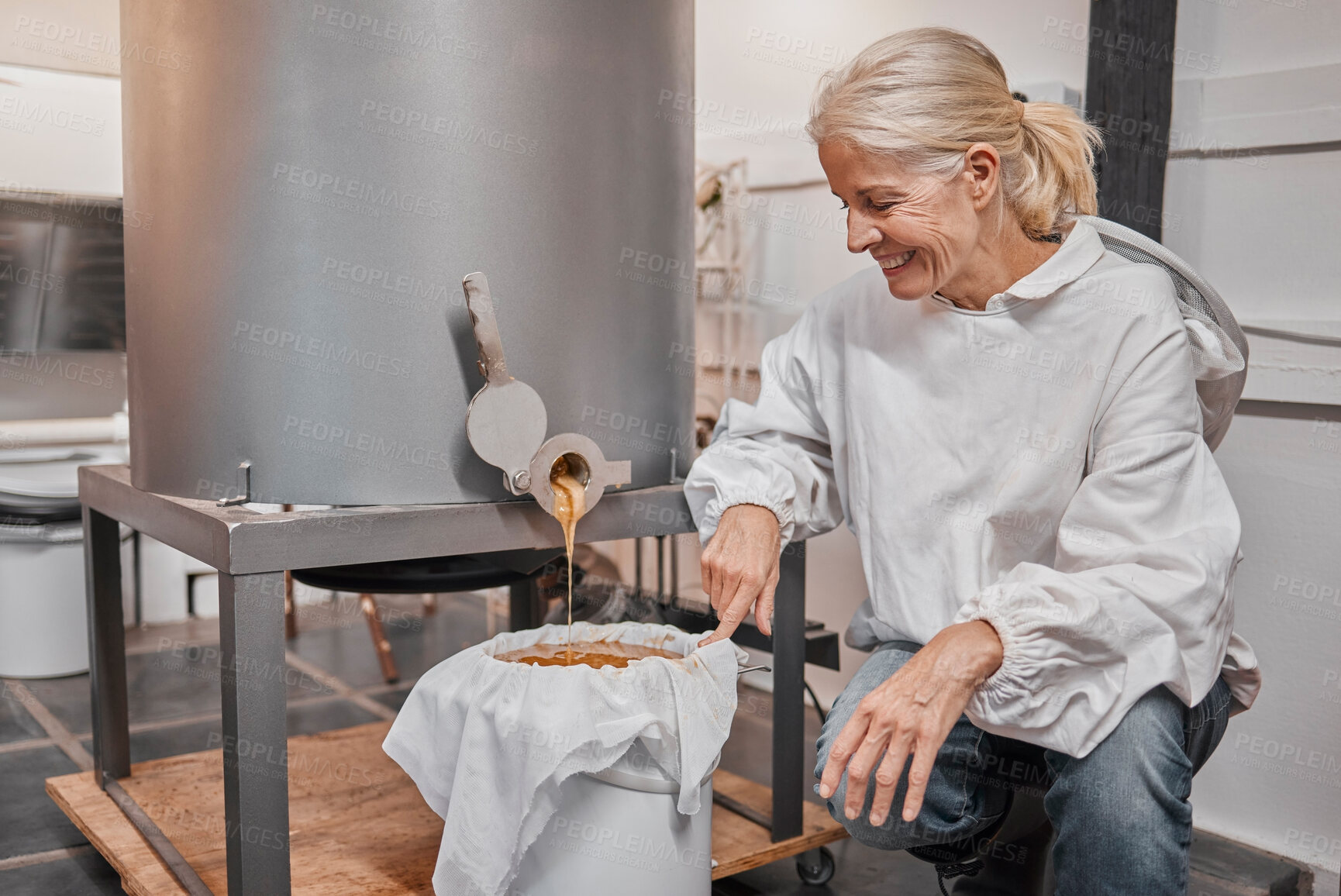 Buy stock photo Happy, smile and beekeeper working with honey for eco friendly, organic and natural production at warehouse. Business owner with happiness for the process of sweet food from a machine in agriculture