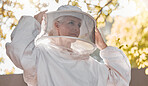 Agriculture, work and beekeeper farm safety suit for  protection, production and harvesting. Nature, worker and beehive woman expert getting ready for inspection, extraction or check.

