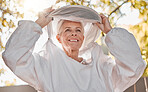 Happy, beekeeper and woman in nature for honey collection, monitor beehive health or check backyard environment. Smile, agriculture and senior apiarist in safety gear ready to start garden inspection