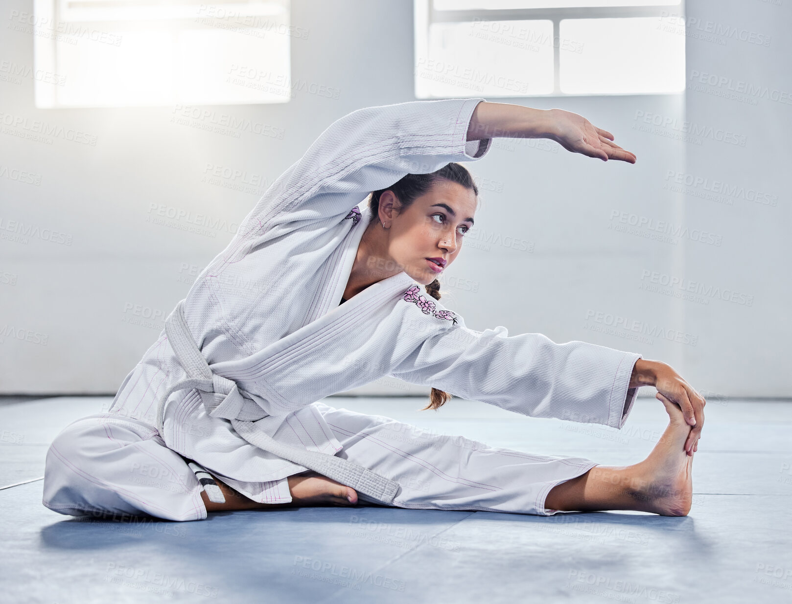 Buy stock photo Martial arts, karate or woman stretching before training practice, fitness workout or challenge competition. Girl, warrior or taekwondo fighter warm up for dojo self defense or safety security lesson