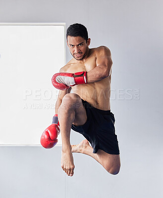 Buy stock photo Muay thai, jump and fitness with man kick boxing for training, martial arts and and sports fight. Action, workout and energy with athlete and boxing gloves for mma, champion and exercise in dojo gym
