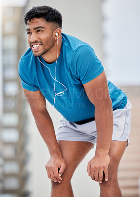 Buy stock photo Fitness, rest and runner stop to relax or breathe on outdoor run or workout with headphones. Health, training and wellness, a tired sports man on break from running exercise while streaming music app