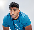 Runner, fitness and tired with a sports man sweating in studio on a gray background for health or cardio. Exercise, running and exhausted with a male athlete breathing while listening to music