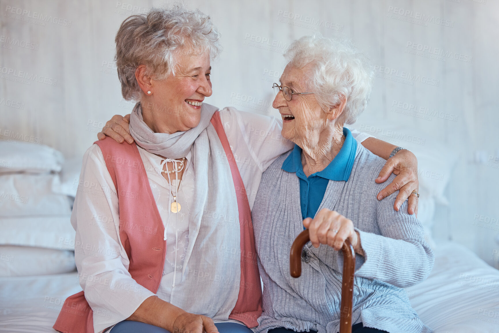 Buy stock photo Senior woman, friends and embrace on bed in house, apartment or nursing home with happiness. Elderly women, hug and smile together in bedroom for care, bonding and best friend love in retirement