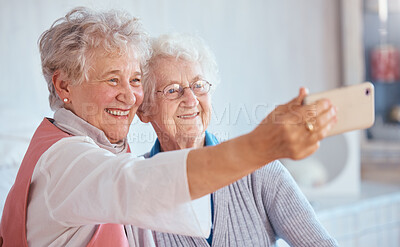 Buy stock photo Phone, selfie and elderly friends smile for pictures to share on social media online while relaxing in retirement. Happy, love and senior women smiling while enjoy quality time at home in Berlin