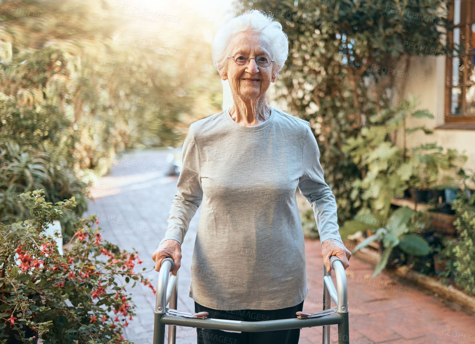 Buy stock photo Disability, rehabilitation and senior woman with walking frame for outdoor wellness, moving body and healthcare in nature, garden or park. Retirement home, elderly care and old lady portrait on walk