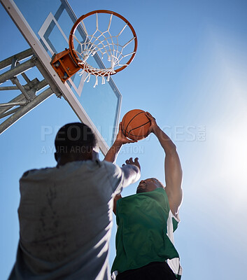 Buy stock photo Basketball player, low angle and competition games on blue sky background of outdoor sports, fitness and energy for goals, performance and action. Basketball hoop, friends and men, court and training