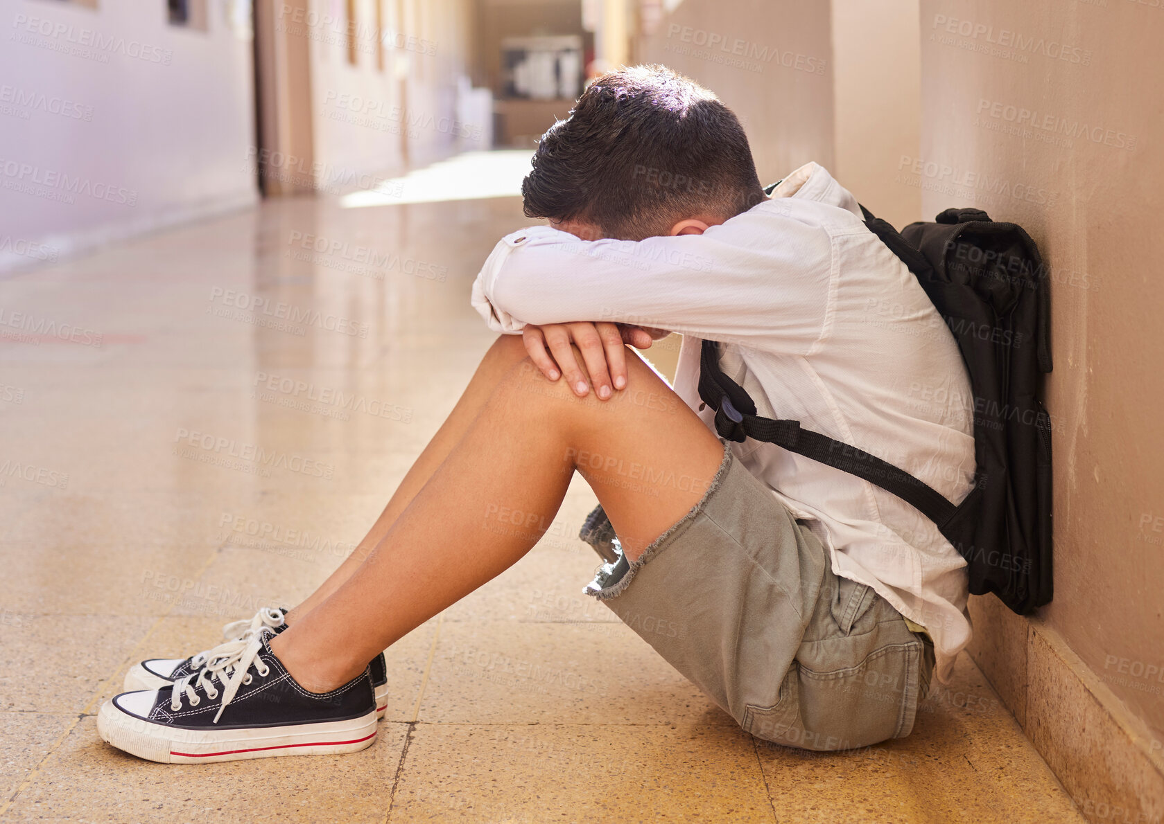 Buy stock photo Anxiety, school and sad student bullying victim feeling depression, lost or stressed in hallway or corridor floor. Child, depressed boy or lonely male learner crying alone with abuse trauma or fear