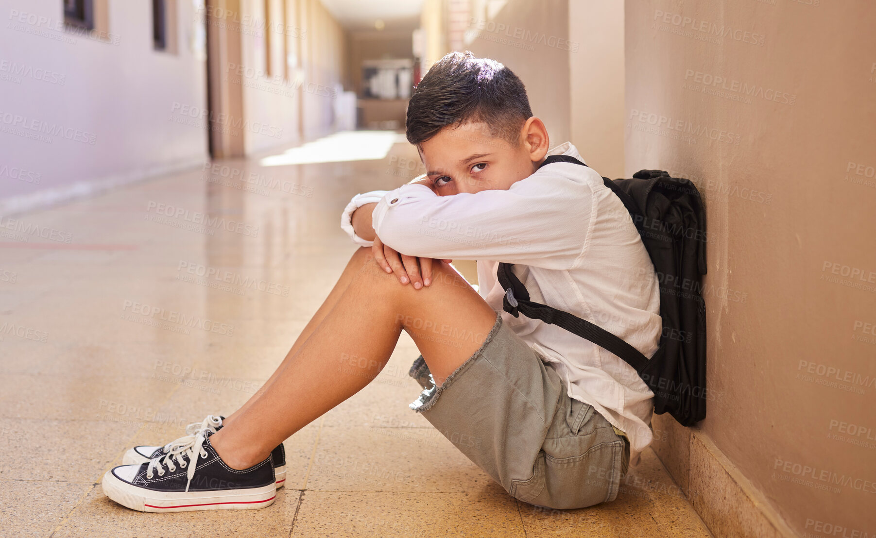 Buy stock photo School child, bullying and sad student on ground for depression, anxiety and autism or learning problem in hallway. Boy feeling stress and depressed after abuse, violence or discrimination portrait