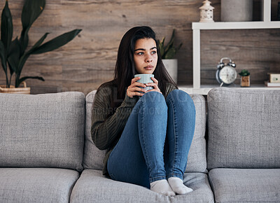 Buy stock photo Depression, sad and woman with coffee on a sofa for thinking, lonely and isolated in a living room. Stress, anxiety and girl drinking tea on couch, looking depressed about debt or mental health