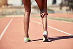 Black woman, runner and legs with injury, pain or strain on track for training, fitness or workout. Athlete woman, running and exercise with muscle strain, calf or leg for sport, race track or field