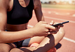 Phone, fitness and woman on social media at a race track to search for running, training or workout content online. Hands, networking app and sports girl resting on a break after exercise to relax 