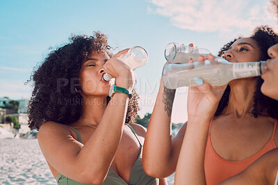 Buy stock photo Beach, friends and African women drink bottle of liquid cold drink to relax on Summer vacation in Nigeria. Nature travel, black woman or thirsty bikini girl drinking lemonade on holiday adventure