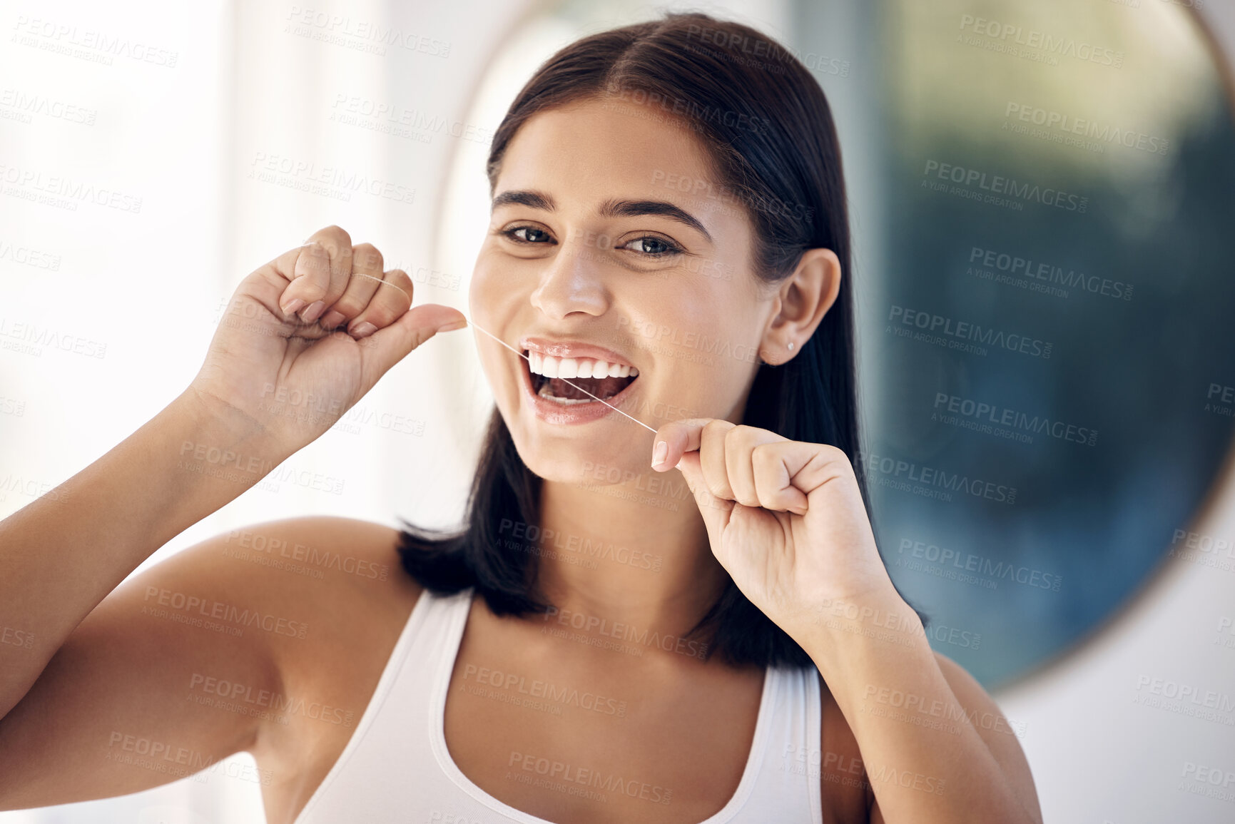 Buy stock photo Smile, woman in bathroom flossing teeth and morning dental care routine in home mirror. Health, wellness and Indian woman with dental floss, motivation for cleaning for healthy mouth and fresh breath