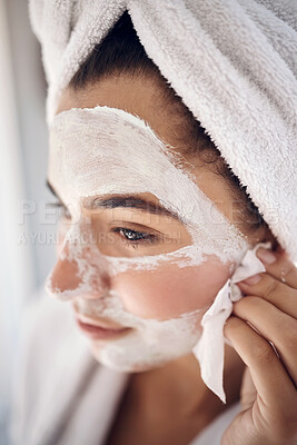 Buy stock photo Facial, skincare and woman peeling a face mask for beauty in a grooming treatment with dermatology products. Relaxed, cream and young girl with tissue to wipe acne lotion cosmetics in a bathroom