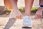 Shoes, running and fitness person hands in nature tying laces for a run, hike or walk. Exercise, training and running workout of an athlete ready for outdoor travel walking for health and sport