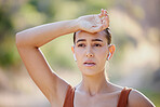 Woman with hand on head, fitness and rest while running and listening to music on earphones on summer morning in Australia. Health, exercise and girl runner taking time for resting on outdoor workout