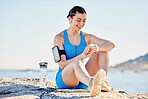 Fitness, beach and time with a sports woman checking her smartwatch during a workout by the ocean. Nature, water and clock with a female athlete tracking her training progress with a sport app